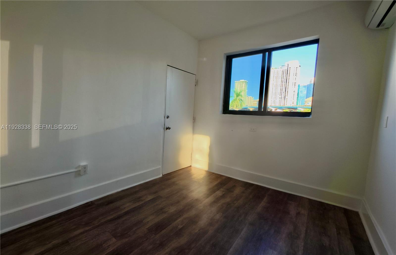 337 Southwest 5th Avenue, Unit 12 Miami, FL 33130 - Photo 17 of 21 a view of an empty room with wooden floor and a window