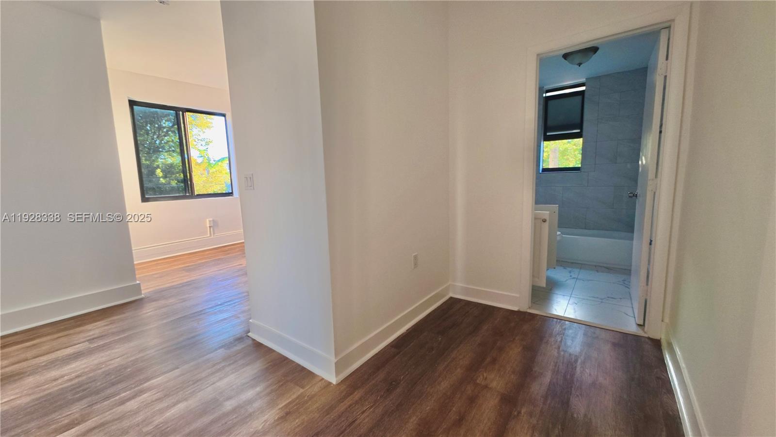 337 Southwest 5th Avenue, Unit 12 Miami, FL 33130 - Photo 19 of 21 an empty room with wooden floor and a window