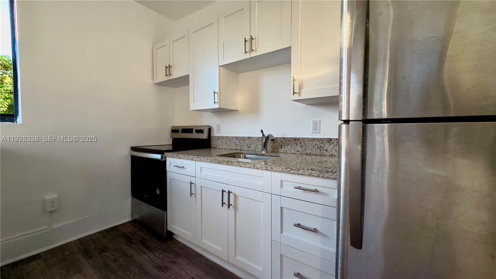 337 Southwest 5th Avenue, Unit 12 Miami, FL 33130 - Photo 4 of 21 a kitchen with stainless steel appliances granite countertop a refrigerator sink and white cabinets