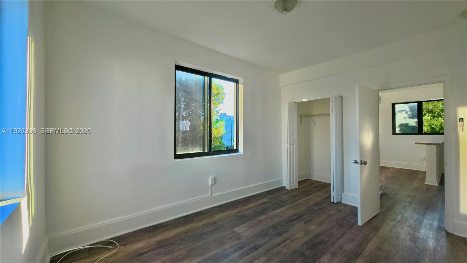 337 Southwest 5th Avenue, Unit 12 Miami, FL 33130 - Photo 10 of 21 an empty room with wooden floor and windows