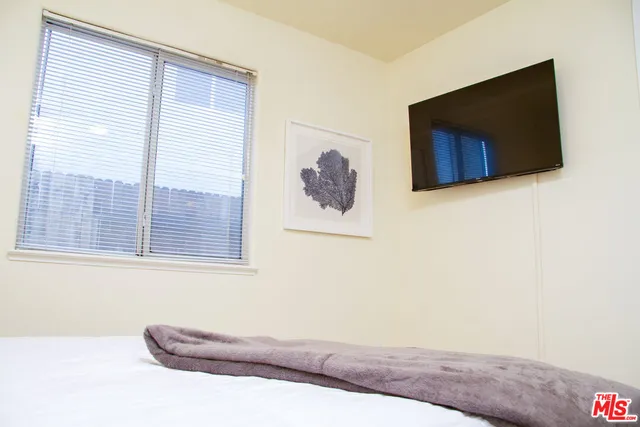 a bedroom with a bed and a painting on the wall