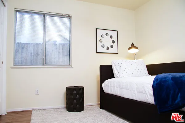 a bedroom with a bed and a painting on the wall