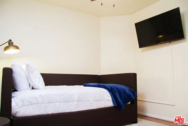 a bedroom with a bed and a painting on the wall