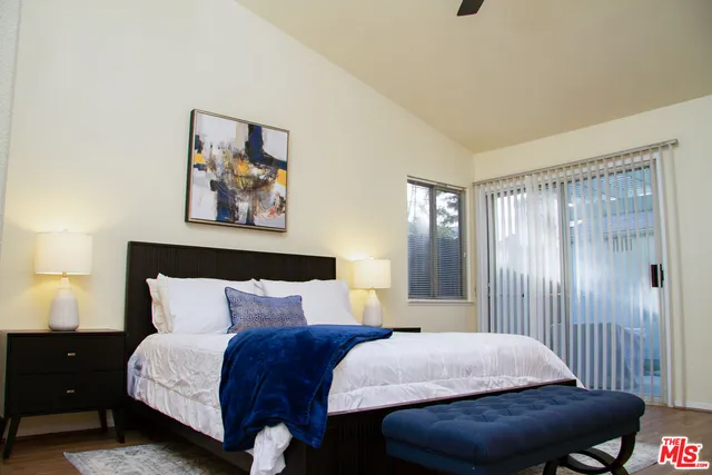 a bedroom with a bed and a painting on the wall