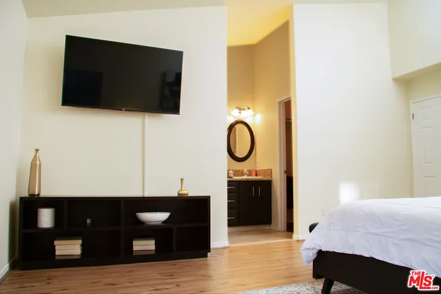 a bedroom with a bed and a painting on the wall