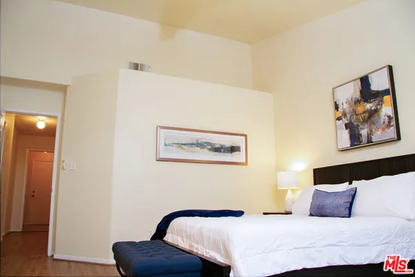a bedroom with a bed and a painting on the wall