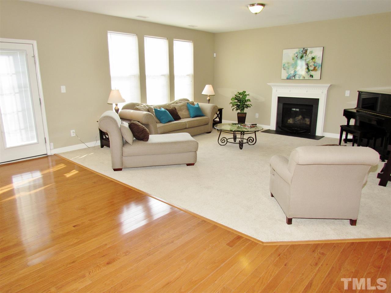 5148 Holly Ridge Farm Road Raleigh, NC 27616 - Photo 5 of 25 a living room with furniture a fireplace and a floor to ceiling window