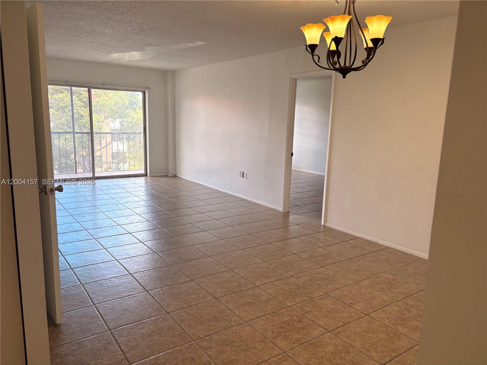 4168 Inverrary Drive, Unit 408 Lauderhill, FL 33319 - Photo 5 of 11 an empty room with windows and chandelier