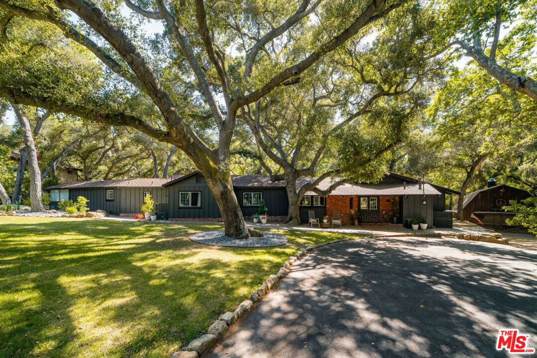 a view of a house with a yard covered with trees