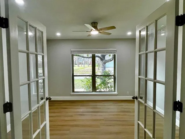 a view of a hallway with a glass door and chandelier