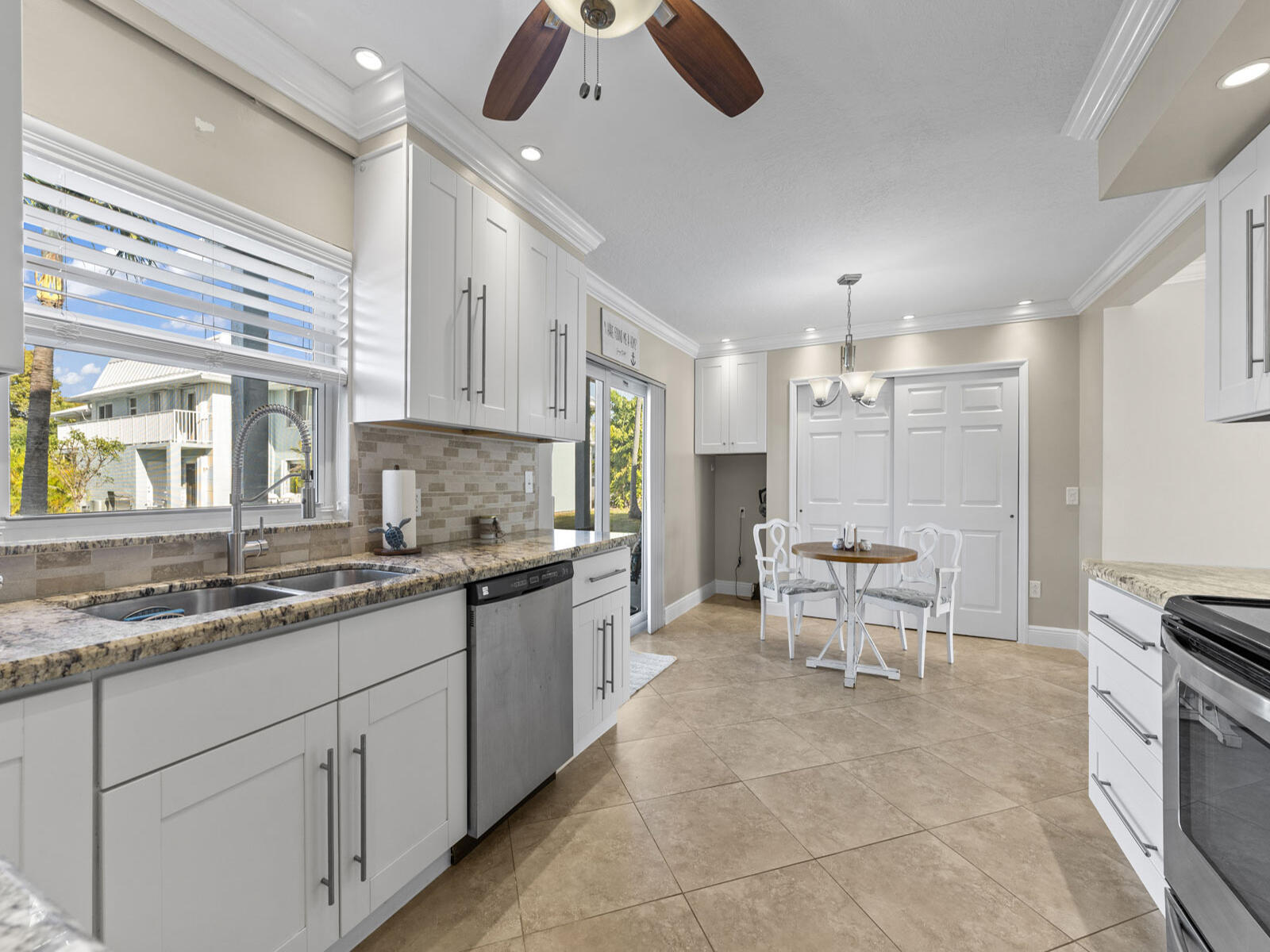 40 High Point Road, Unit D102 Tavernier, FL 33070 - Photo 11 of 37 a large kitchen with kitchen island granite countertop a sink and white appliances