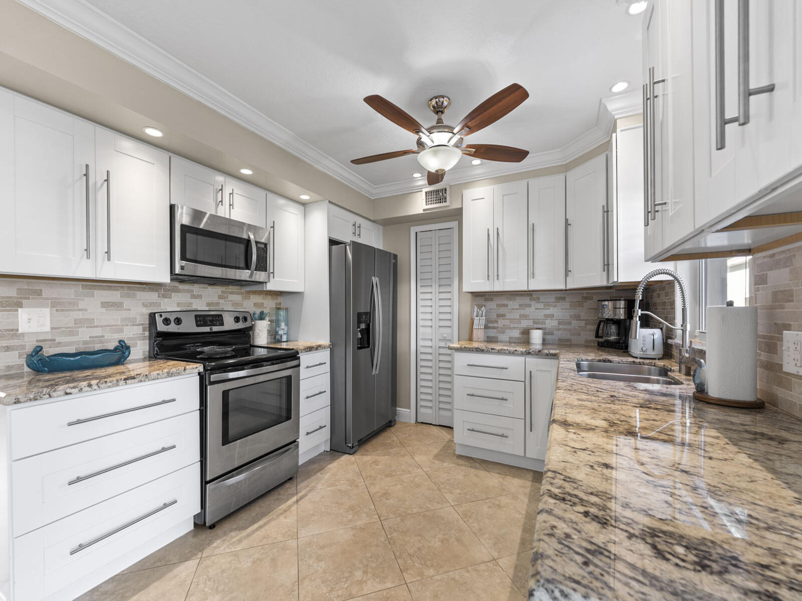 40 High Point Road, Unit D102 Tavernier, FL 33070 - Photo 9 of 37 a kitchen with stainless steel appliances granite countertop a stove top oven a refrigerator a sink and dishwasher