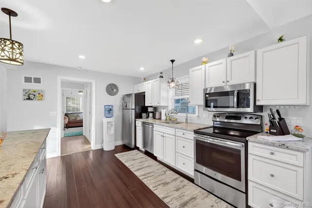 a large kitchen with a lot of counter space and wooden floor