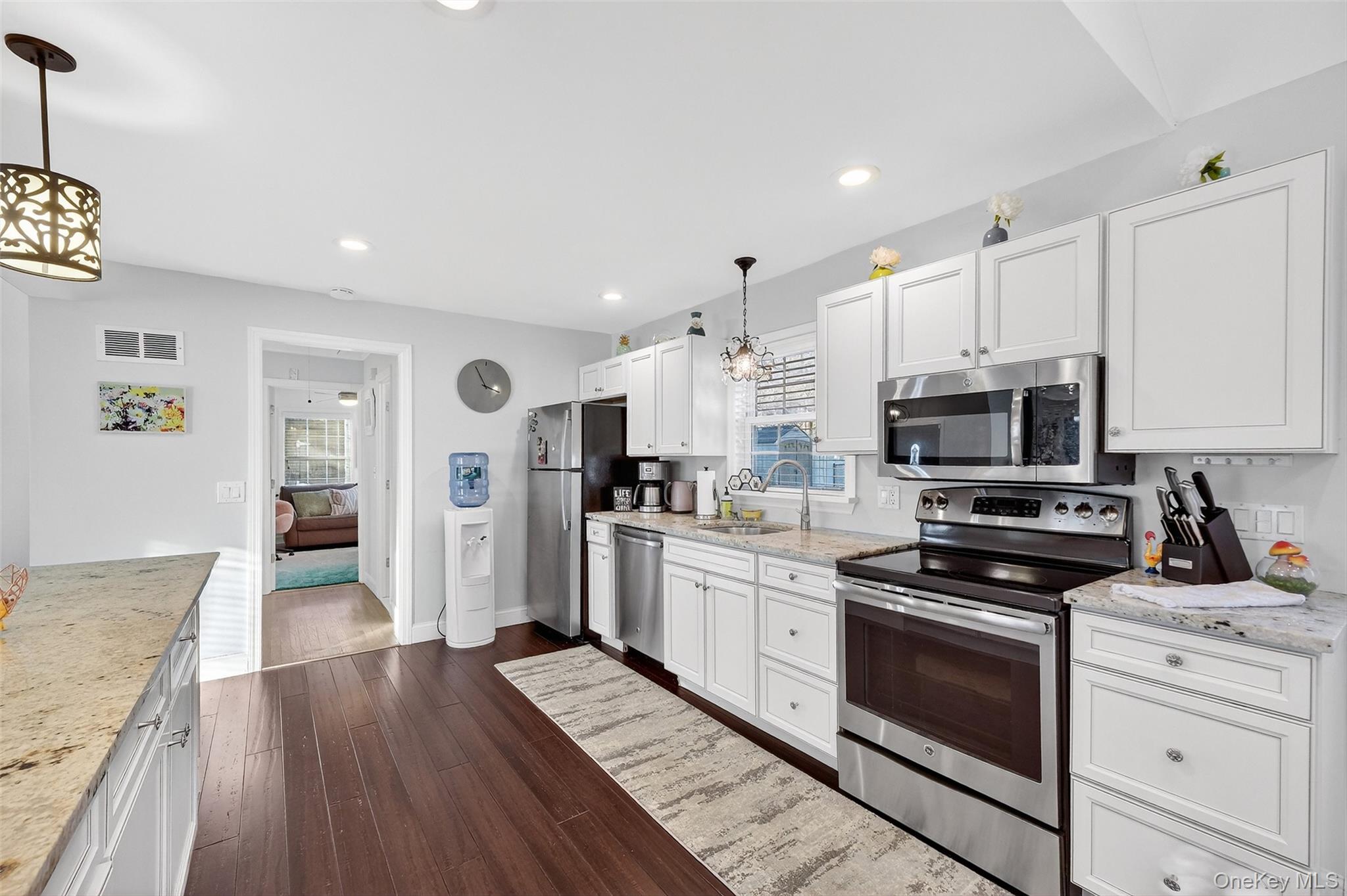 550 Beach Road Mahopac, NY 10541 - Photo 13 of 38 a kitchen with stainless steel appliances granite countertop a stove top oven a sink dishwasher and a refrigerator with wooden floor