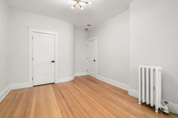 an empty room with wooden floor and a window