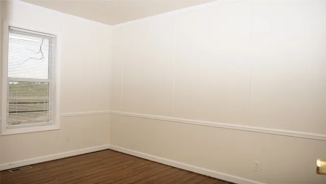 a view of a small space with wooden floor and a window