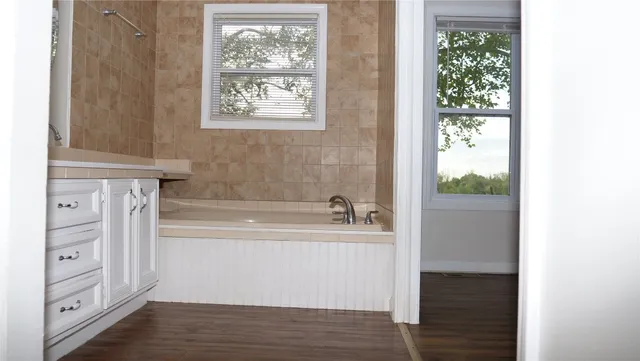 a bathroom with a bathtub and a window