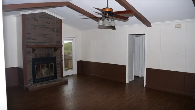 a living room with wooden floor and a fireplace