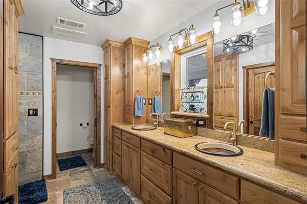 a bathroom with a sink double vanity granite tub and shower