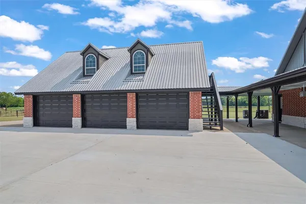 a front view of a house with yard and parking