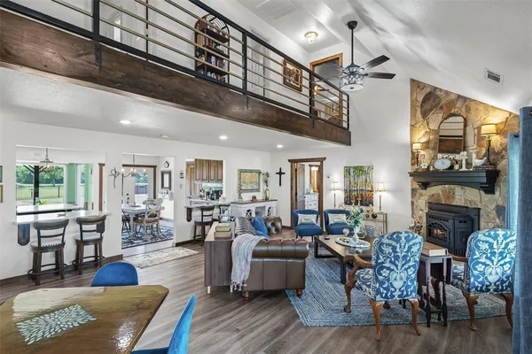 a living room with furniture a fireplace and a dining table with wooden floor