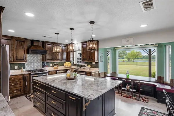 a kitchen with stainless steel appliances granite countertop a sink stove and refrigerator