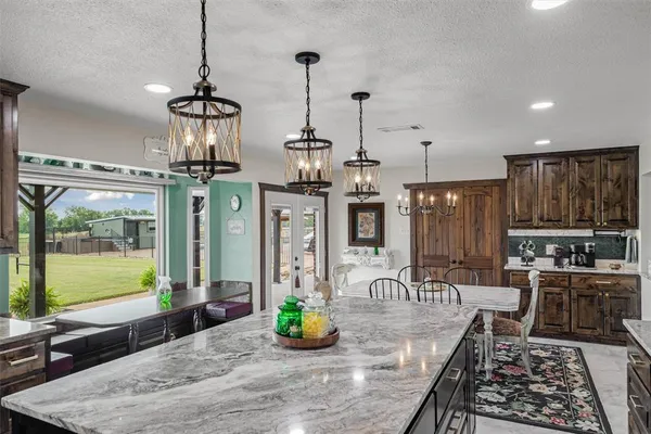 a kitchen with stainless steel appliances granite countertop a sink a stove and a wooden floors