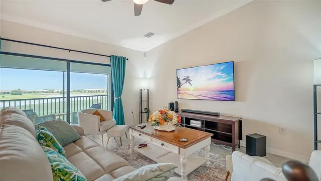 a living room with furniture floor to ceiling window and a flat screen tv