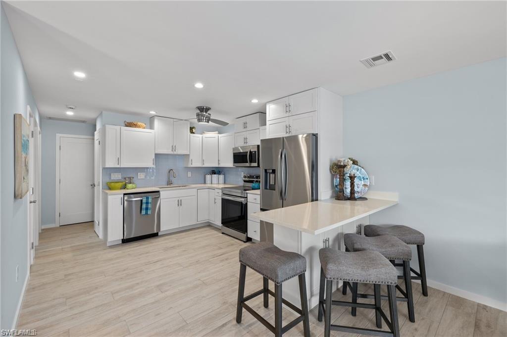 1435 Curlew Avenue, Unit 3 Naples, FL 34102 - Photo 5 of 28 a kitchen with a refrigerator and chairs