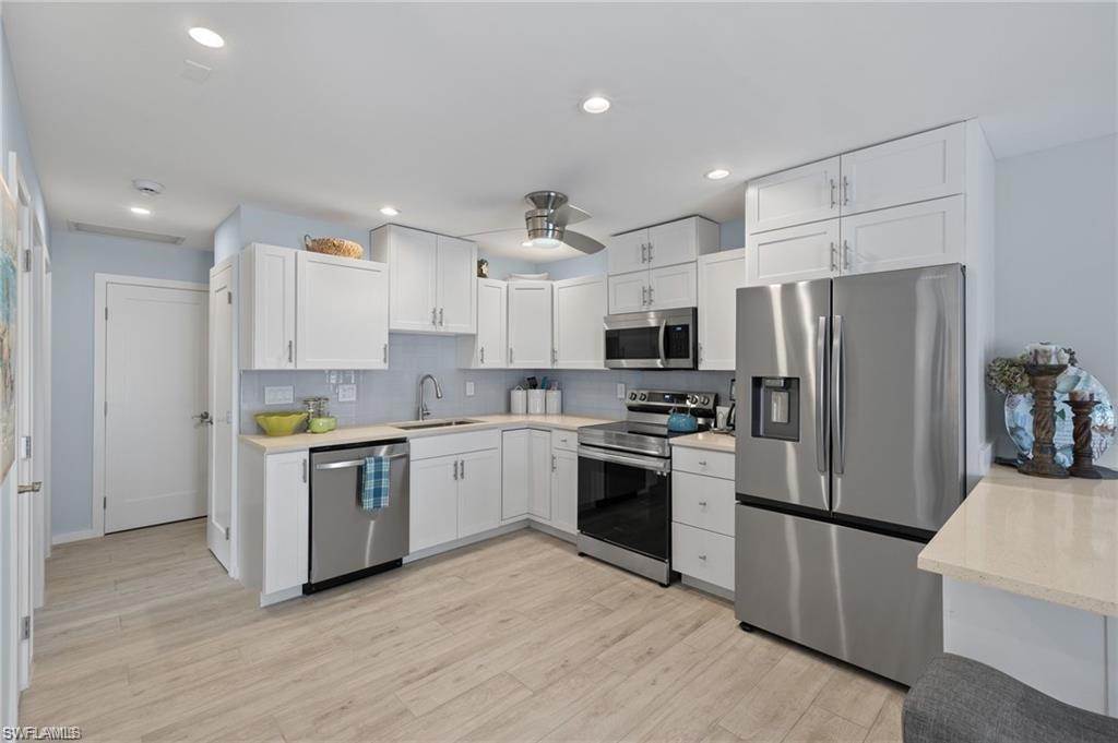 1435 Curlew Avenue, Unit 3 Naples, FL 34102 - Photo 6 of 28 a kitchen with stainless steel appliances granite countertop a refrigerator a stove top oven a sink and dishwasher