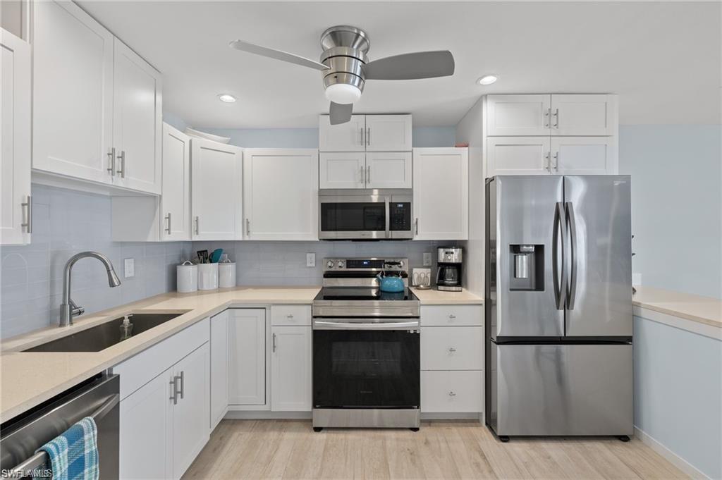 1435 Curlew Avenue, Unit 3 Naples, FL 34102 - Photo 7 of 28 a kitchen with stainless steel appliances a refrigerator sink and white cabinets