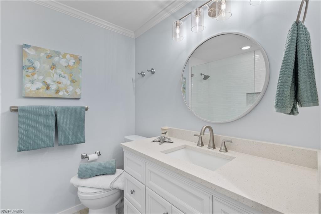 1435 Curlew Avenue, Unit 3 Naples, FL 34102 - Photo 10 of 28 a bathroom with a toilet a sink and mirror