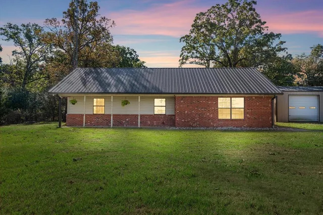 a view of a yard in front of a house with large trees