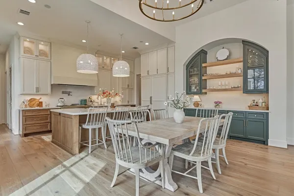 a large white kitchen with a large window and stainless steel appliances
