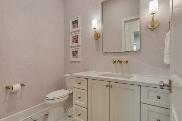 a bathroom with a sink a toilet and a mirror