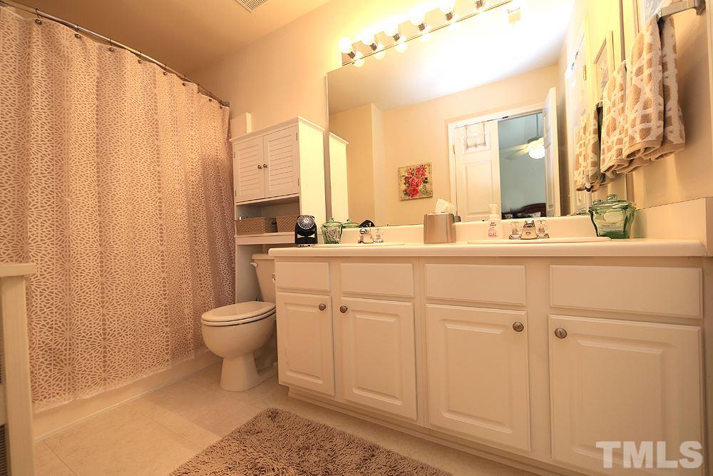 8113 Rhiannon Road Raleigh, NC 27613 - Photo 7 of 12 a bathroom with a double vanity sink toilet and a mirror