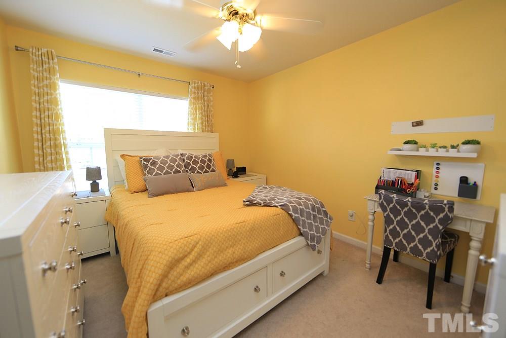 8113 Rhiannon Road Raleigh, NC 27613 - Photo 8 of 12 a bedroom with a bed and a chandelier