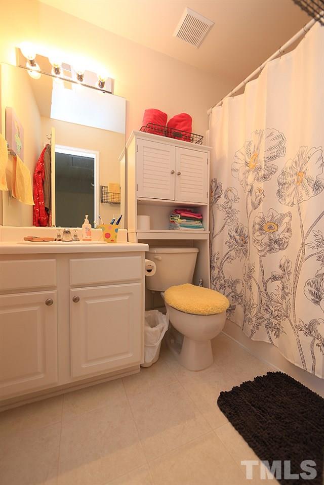 8113 Rhiannon Road Raleigh, NC 27613 - Photo 9 of 12 a bathroom with a toilet sink vanity and mirror