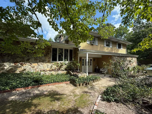 a front view of house with yard and trees around