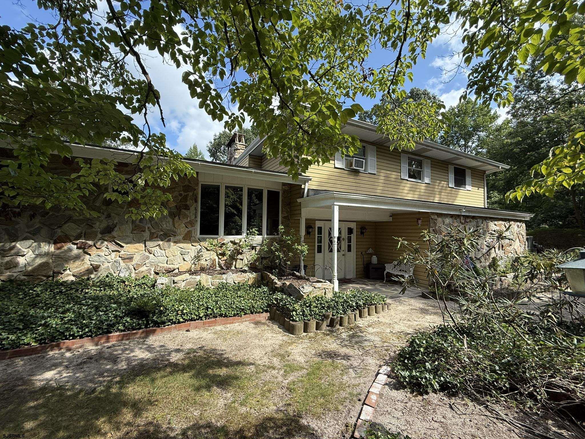 a front view of house with yard and trees around
