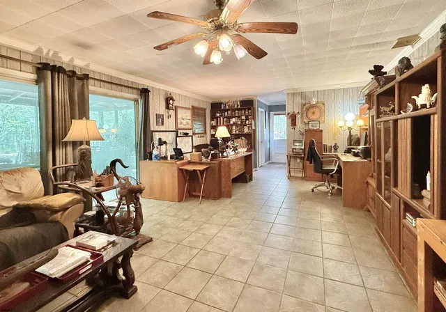 a living room with furniture a chandelier and a dining table
