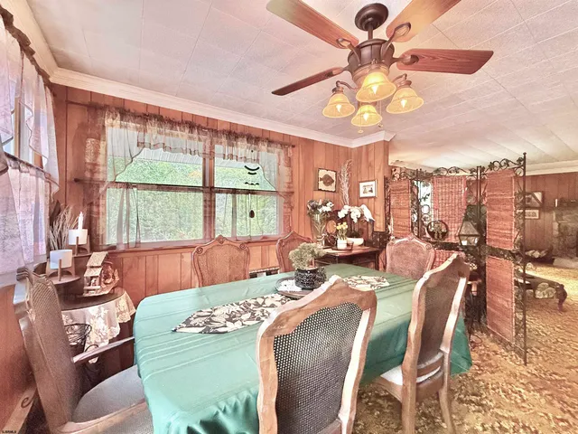 a view of a dining room with furniture a chandelier and a large window