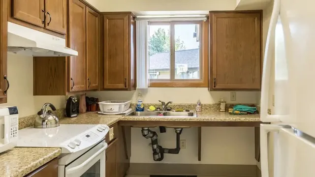a kitchen with stainless steel appliances granite countertop a sink stove and cabinets