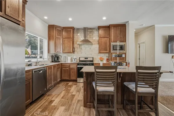 a kitchen with kitchen island granite countertop wooden floors and white stainless steel appliances