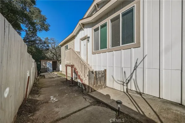 a view of a house with backyard and wooden fence