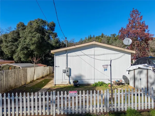 a white building that has a tree in front of it