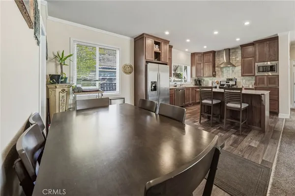 a kitchen with a dining table chairs and refrigerator