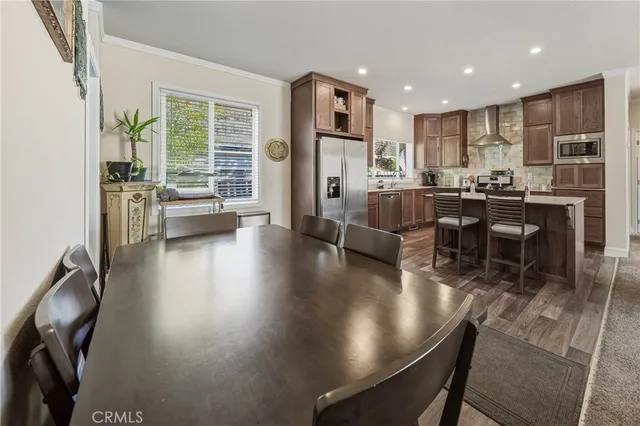a kitchen with a dining table chairs and refrigerator