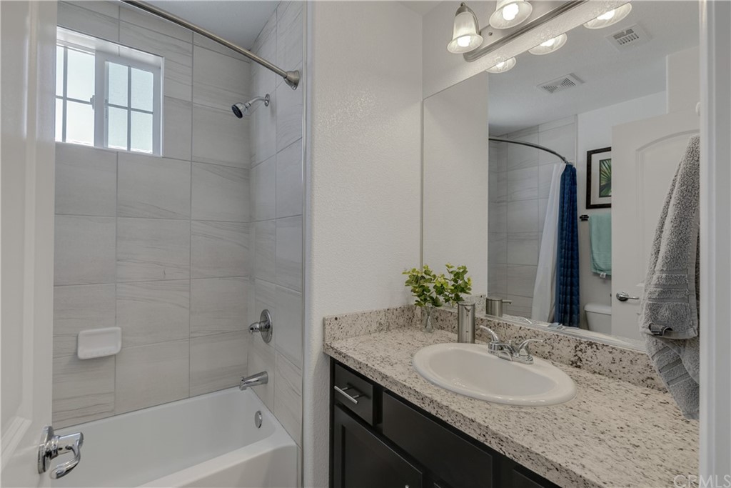 9016 Kimberly Ln. Cypress, CA 90630 - Photo 11 of 21 a bathroom with a granite countertop sink a mirror a vanity and a bathtub