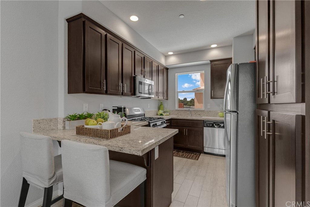 9016 Kimberly Ln. Cypress, CA 90630 - Photo 6 of 21 a kitchen with a refrigerator a stove a sink and a cabinets